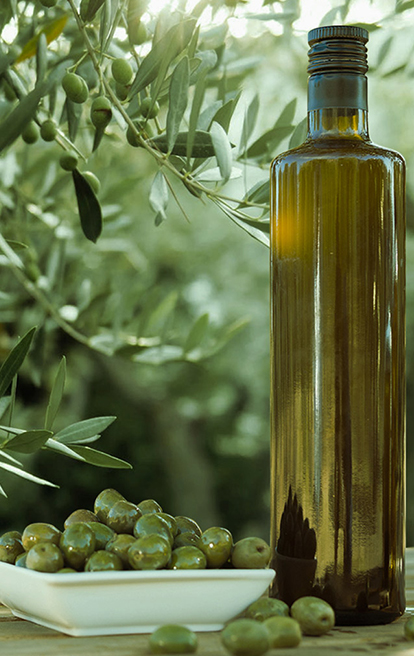 Certified Origins olive oil bottle and olives on table in olive grove Italy